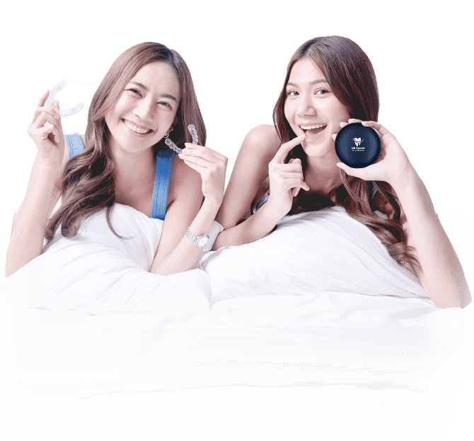 Two women smiling with clear aligners and E-Zee Aligner case on bed