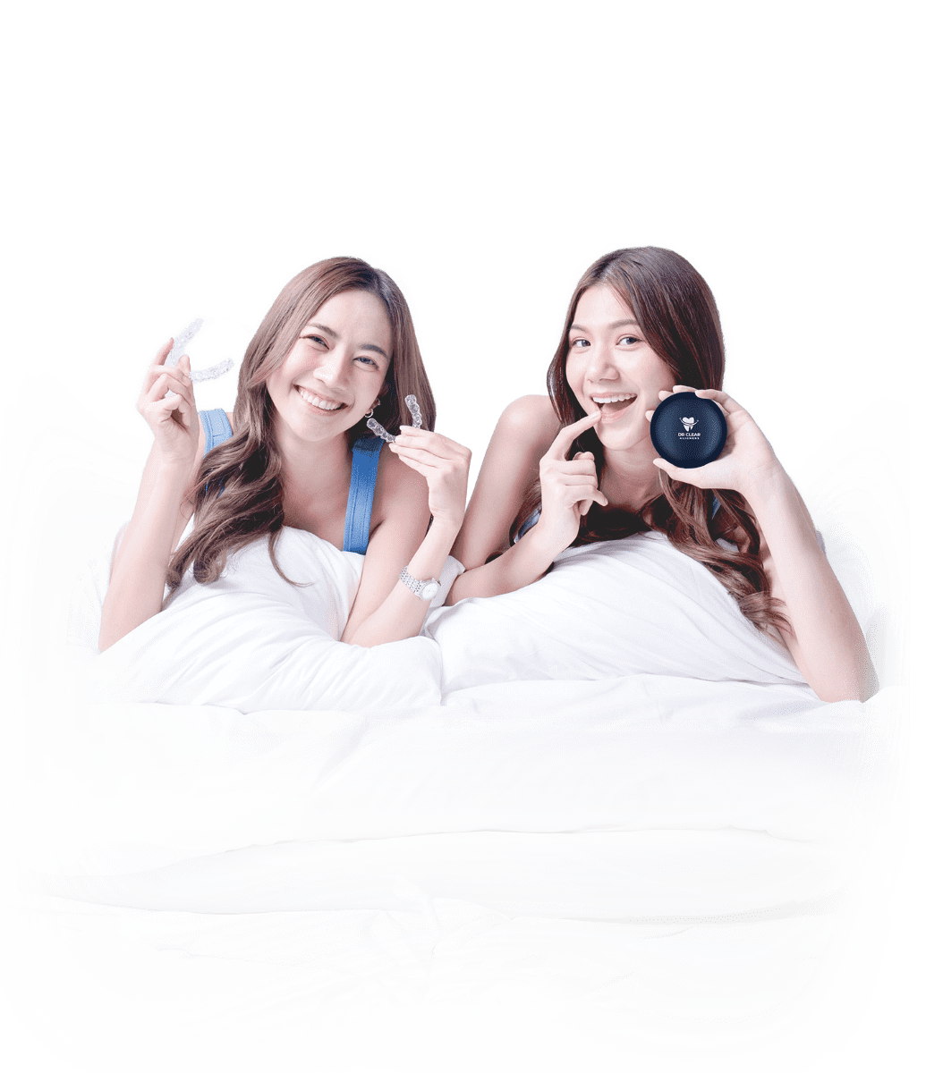 Two women smiling with clear aligners and E-Zee Aligner case on bed